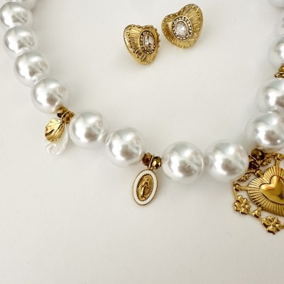 Conjunto de colar e brincos com pérolas e elementos dourados sobre fundo branco