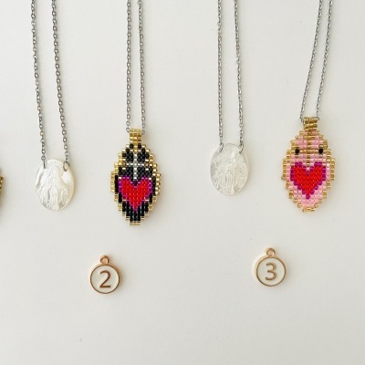 Quatro colares com medalhões metálicos e bordados em fundo branco, etiquetas 2 e 3