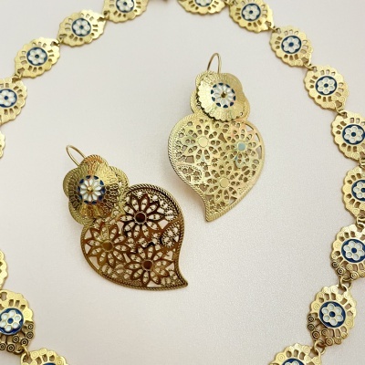 Conjunto de bijuteria dourada com padrões florais e esmalte azul e branco