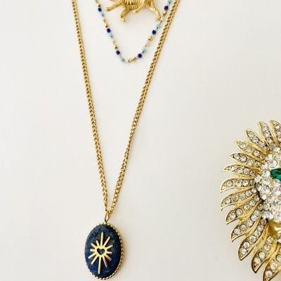 Colares dourados com pingentes e broche com pedras brilhantes