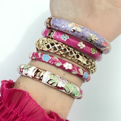 Conjunto de cinco pulseiras florais coloridas com detalhes dourados no pulso