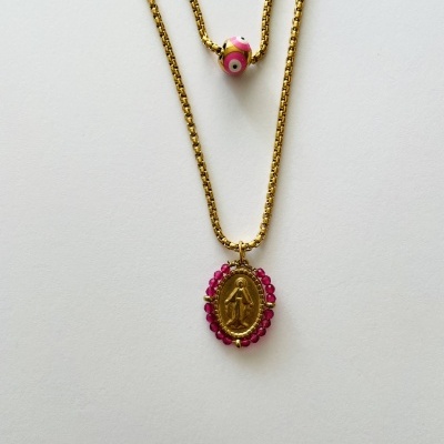 Colares dourados com pendente oval e conta rosa sobre fundo branco.