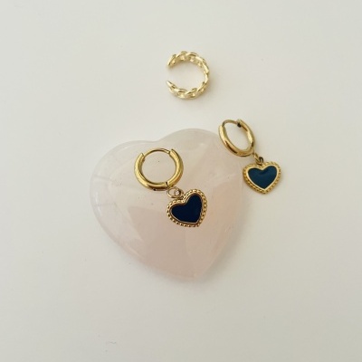Três peças de joalharia douradas com coração azul e pedra rosa em formato de coração