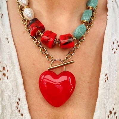 Colar com pingente coração vermelho e contas coloridas, usado com blusa branca