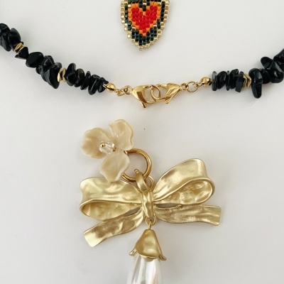 Colar com pendentes em coração colorido e elemento dourado com flor e laço