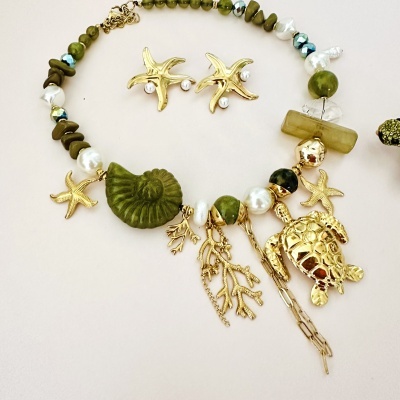 Colar e brincos com elementos marinhos dourados e pedras verdes