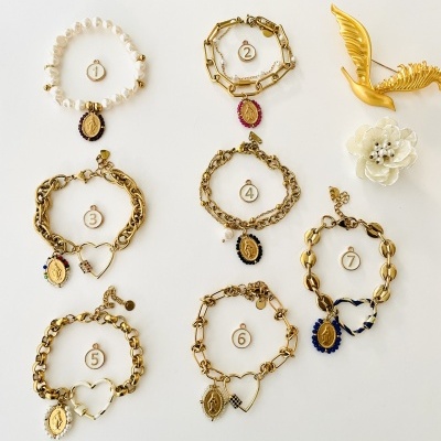 Sete pulseiras douradas numeradas e acessórios decorativos sobre fundo branco
