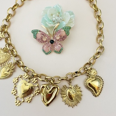 Colar dourado com pendentes de coração e broche de borboleta colorida