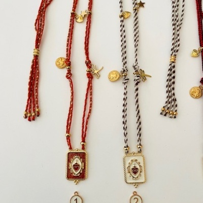 Colares trançados vermelhos e pretos com branco com pendentes retangulares e etiquetas numeradas