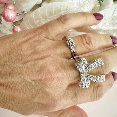 Mão com anéis prateados e decoração natalícia