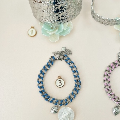 Pulseira azul com pendentes, bracelete prateado texturizado e flores azuis