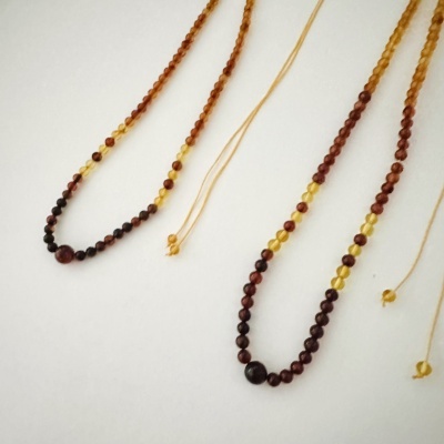 Dois colares de contas cor âmbar em fundo branco