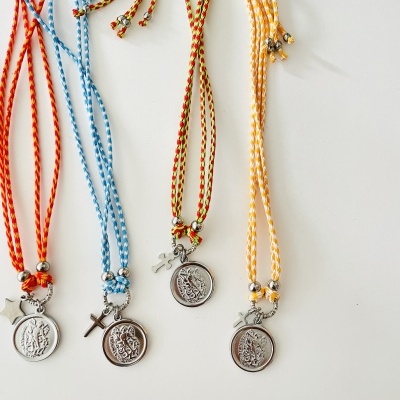 Colares coloridos com medalhões redondos de metal e pingentes variados sobre fundo branco