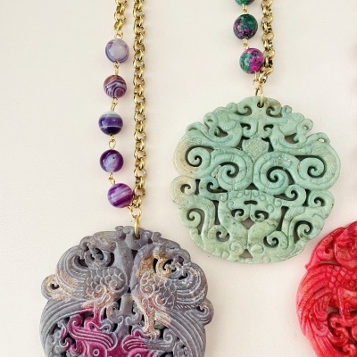 Colares com pendentes esculpidos em pedra com detalhes e correntes douradas