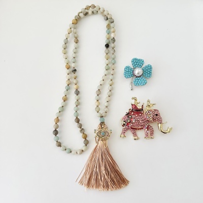 Colar de contas e dois broches decorativos