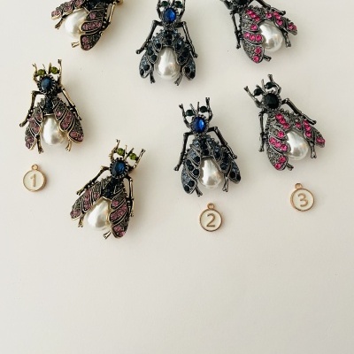 Broches em forma de mosca com pedras coloridas e pérolas, numerados de 1 a 3