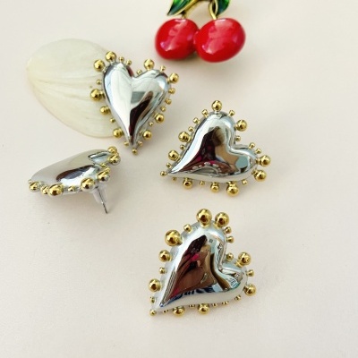 Brincos em forma de coração prateados com detalhes dourados e broche de cerejas vermelhas