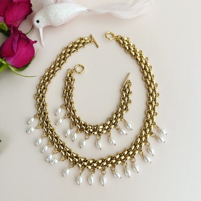 Conjunto dourado com pérolas, fundo branco com rosas vermelhas e ornamento de pássaro