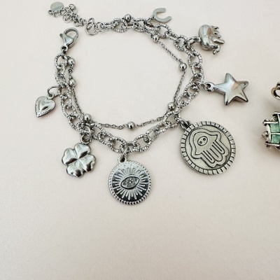 Pulseira prateada com medalhas diversas