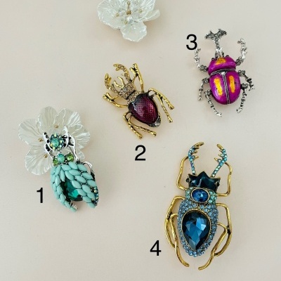 Broches de insetos decorativos numerados sobre fundo bege