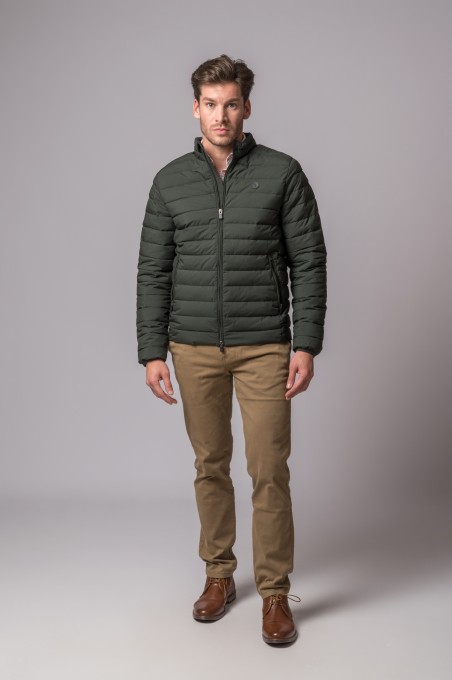 Homem com casaco acolchoado verde escuro e calças castanhas