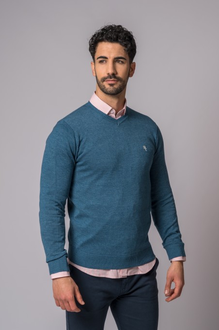 Homem com camisola azul e camisete rosa às riscas