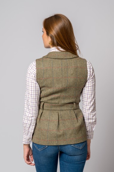 Colete cinza com padrão quadriculado sobre camisa branca com padrões quadriculados, visto de costas