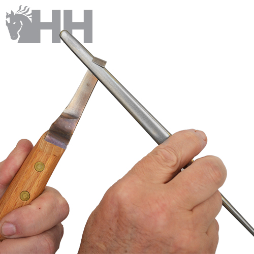 Pessoa a afiar faca com chaira metálica e cabo de madeira em fundo branco com logotipo HH