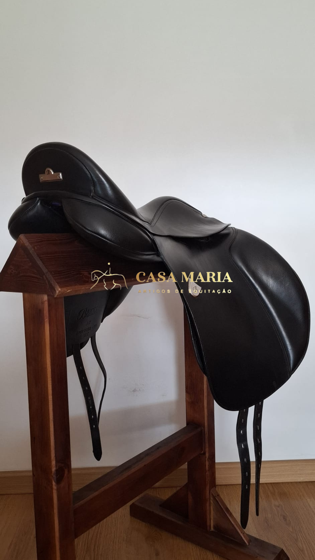 Sela de equitação preta em suporte de madeira