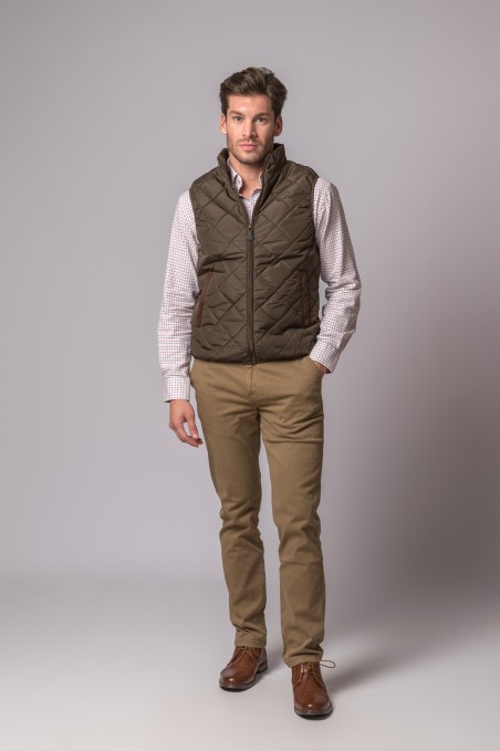 Homem com colete acolchoado castanho-escuro e calças castanhas