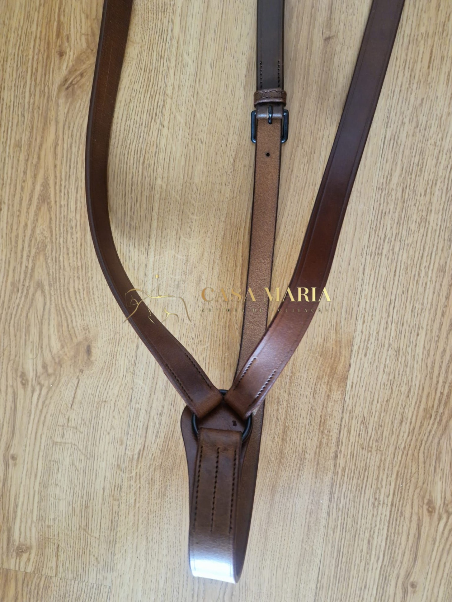 Correia de couro castanha sobre madeira clara com fivela preta