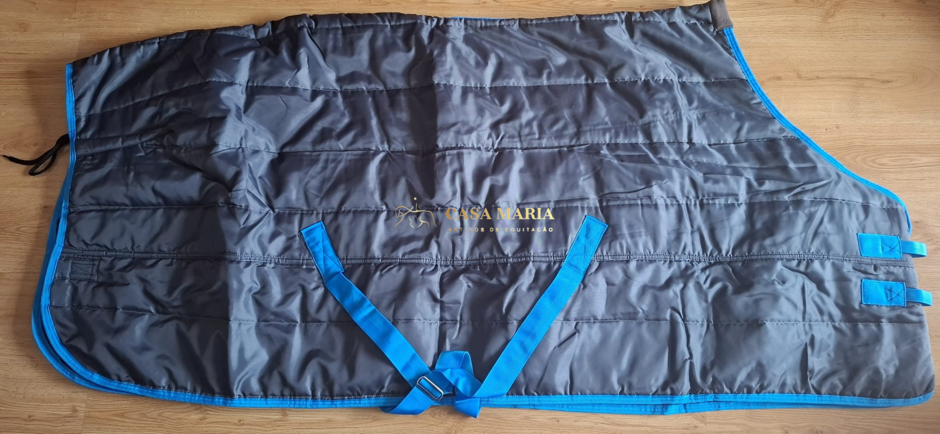 Capa para cavalo cinza escuro com acabamento azul e tiras de ajuste azuis