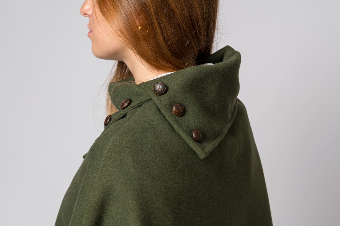 Detalhe de casaco verde militar com capuz e botões castanhos