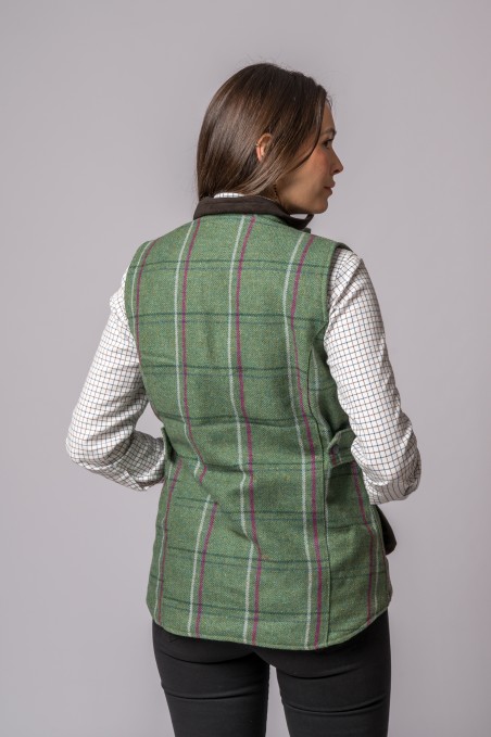 Colete verde às riscas visto de costas sobre camisa branca às quadrículas.