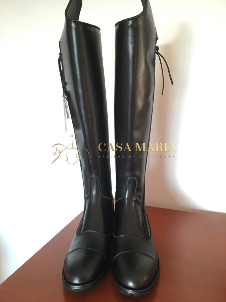 Botas altas pretas de couro com laço atrás e costuras, em fundo branco