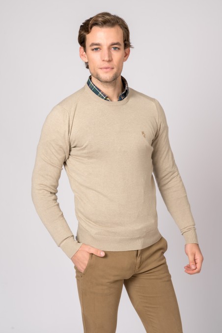 Homem com camisola bege de malha e calças castanhas