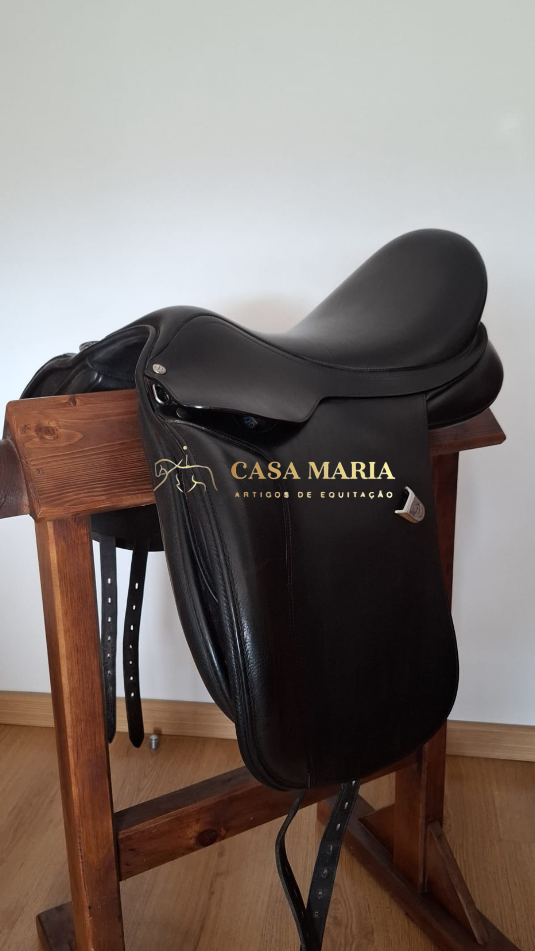 Sela de equitação preta em suporte de madeira