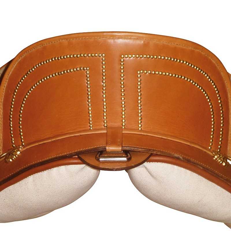 Sela de montaria em couro castanho com tachas douradas e assento bege