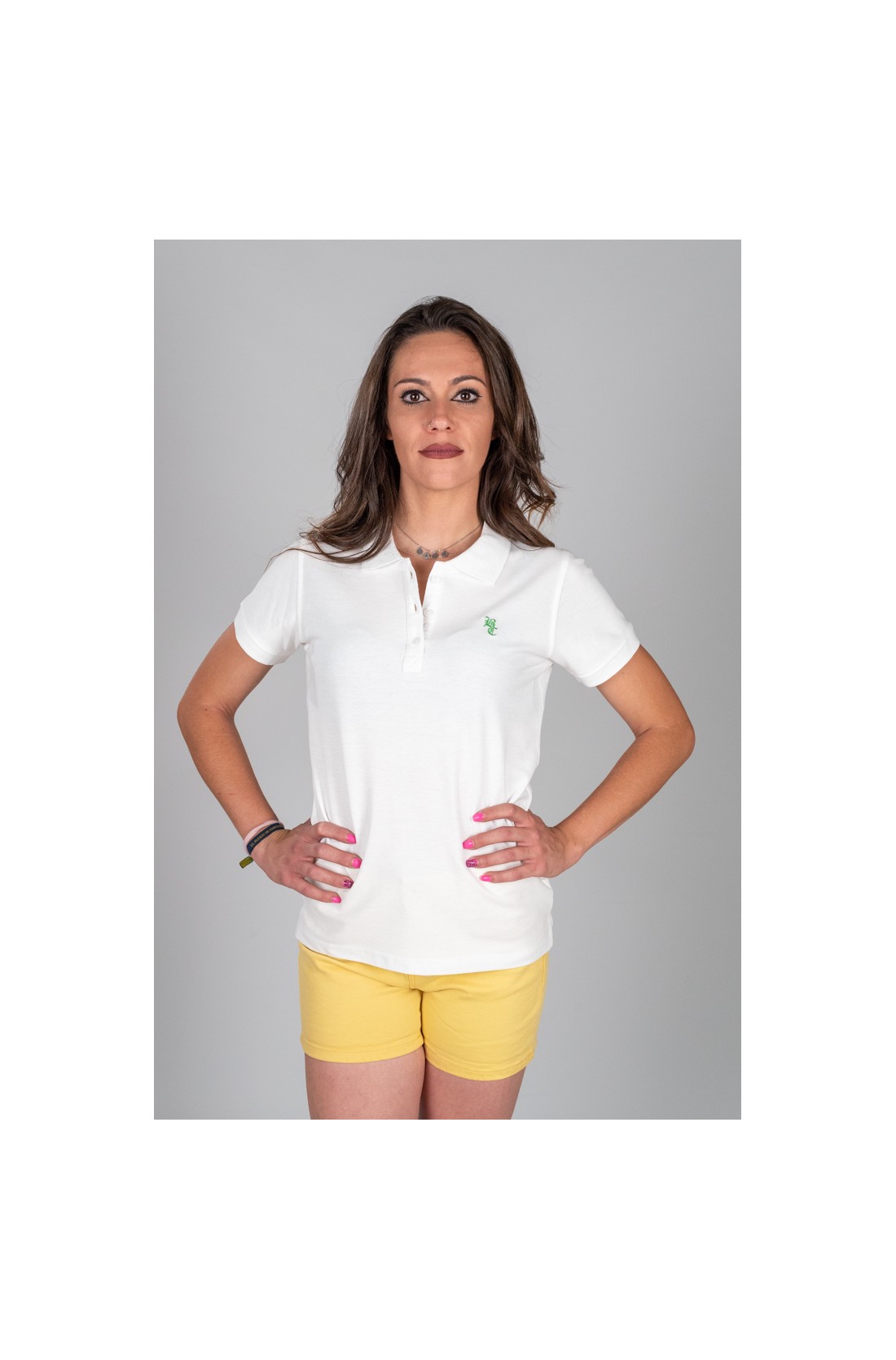 Mulher de camisola branca e calções amarelos em fundo cinzento