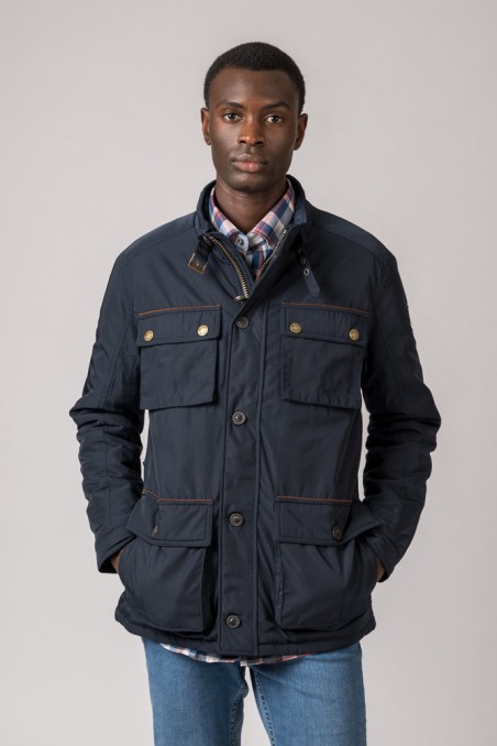 Casaco azul escuro com bolsos usados sobre camisa xadrez e calças de ganga