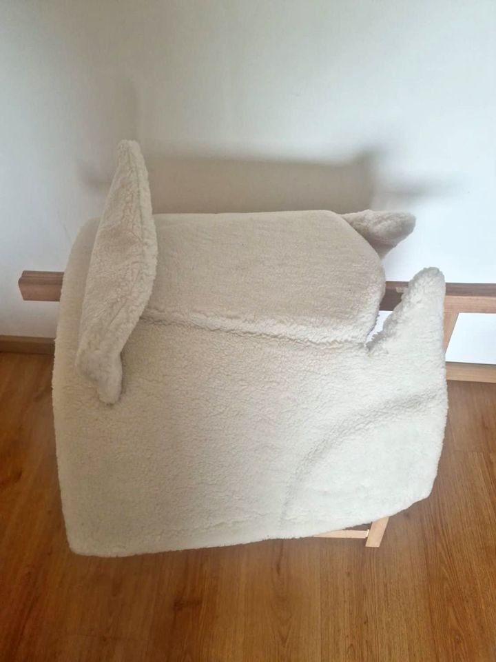 Cobertura branca felpuda para assento sobre suporte de madeira
