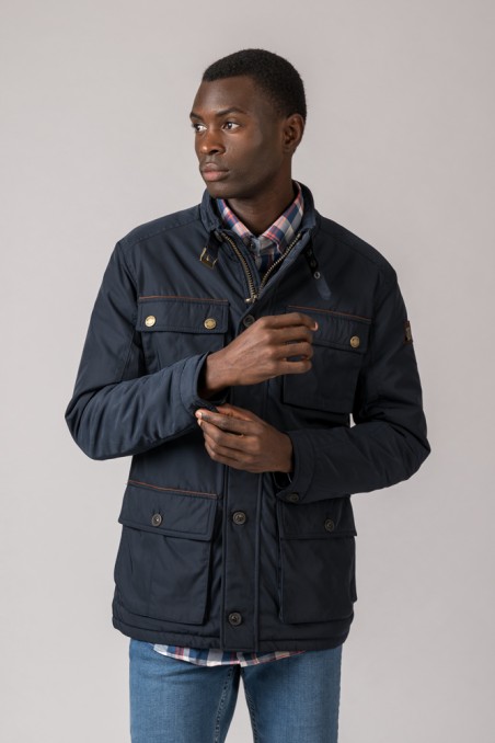 Homem usando casaco azul escuro com bolsos e camisa xadrez debaixo