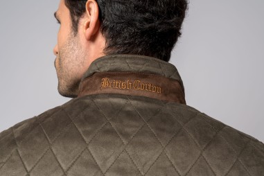 Colarinho de jaqueta verde-oliva matelassada com texto bordado British Cotton