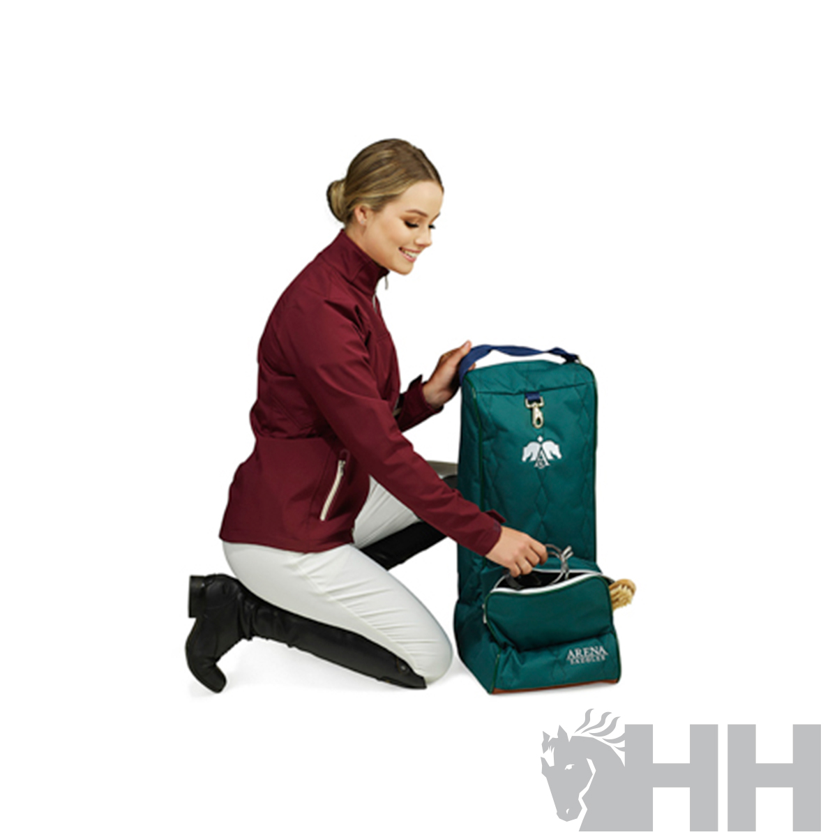 Mochila verde escura com detalhes em azul e branco ao lado de mulher com casaco vinho e calças brancas