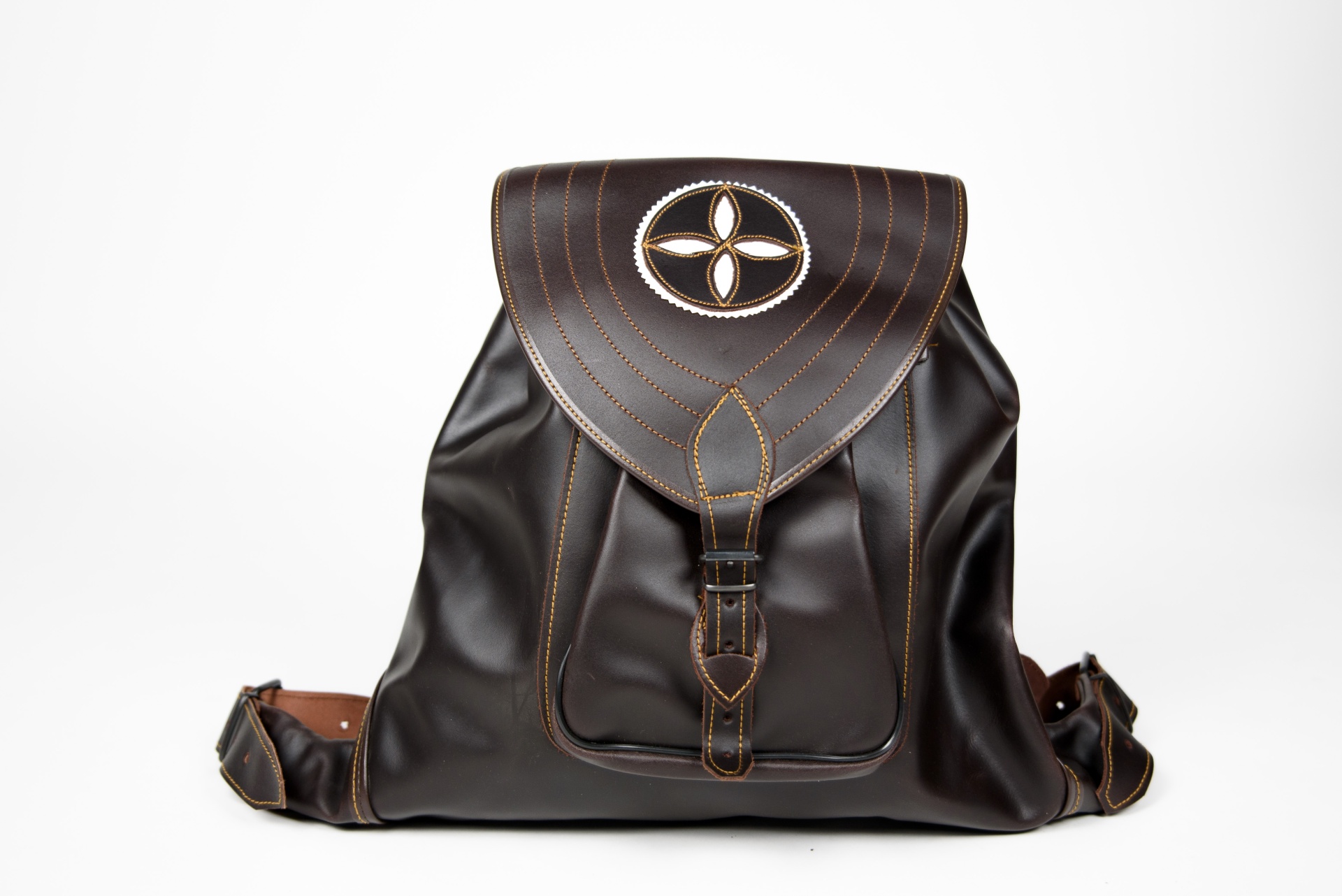 Mochila de couro castanho escuro com fecho e símbolo decorativo