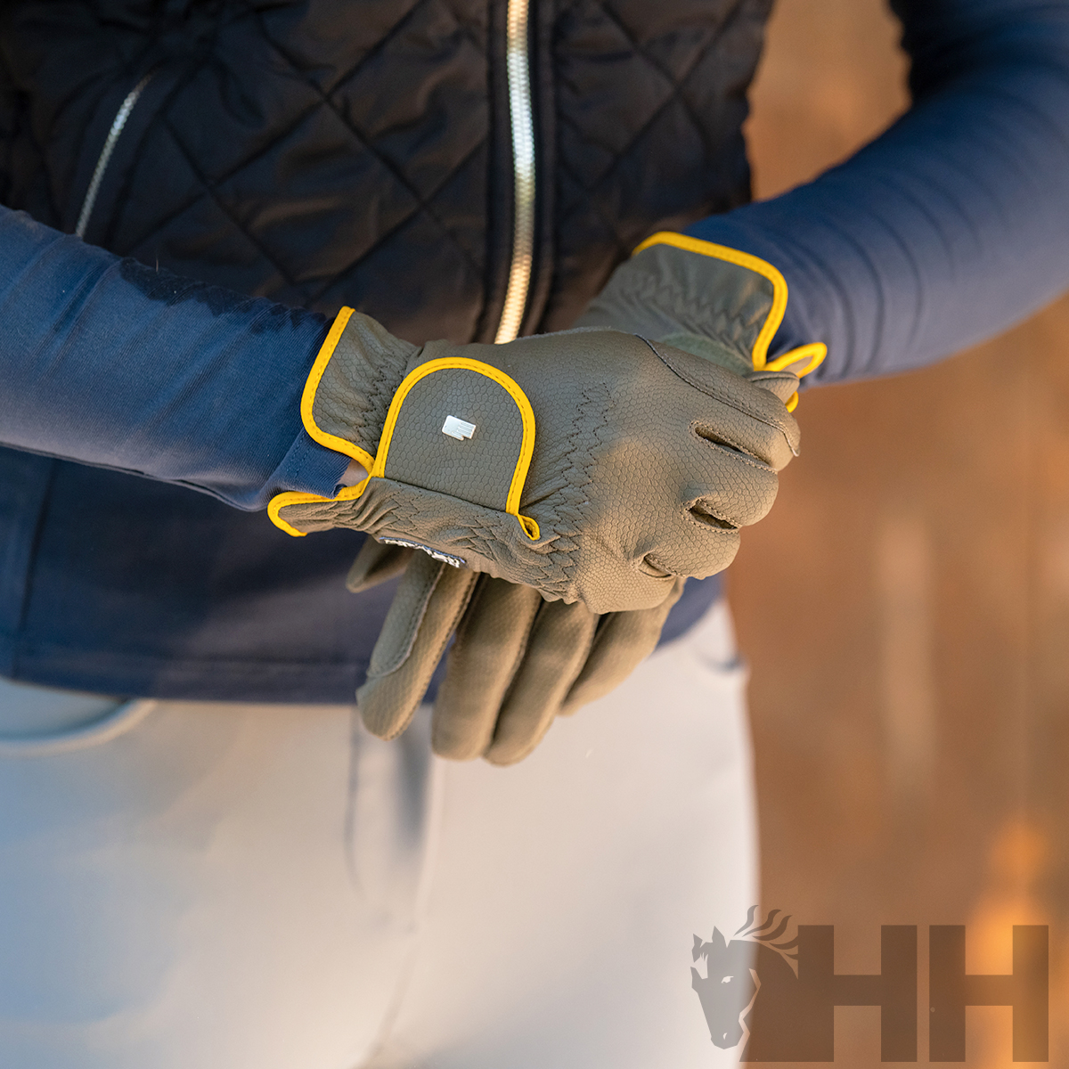 Luvas cinzentas com detalhes amarelos fluorescentes usadas nas mãos de uma pessoa