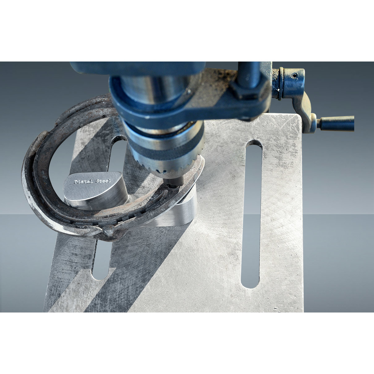 Ferradura de cavalo em metal com máquina de ferramentas azul