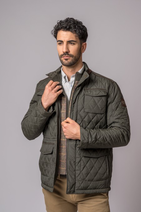 Homem a usar casaco verde escuro acolchoado com bolsos, sobre camisa branca