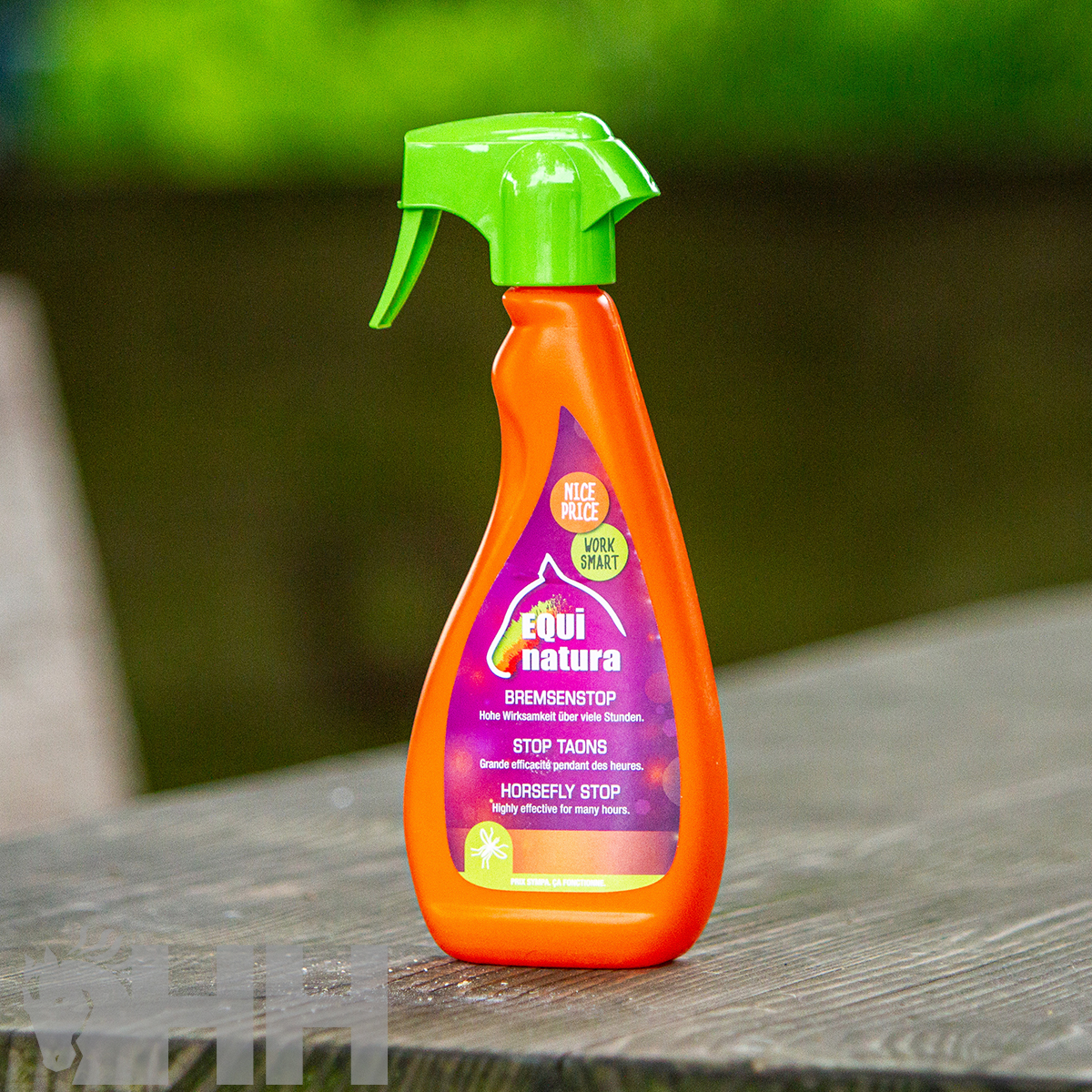 Spray laranja com tampa verde sobre mesa de madeira ao ar livre