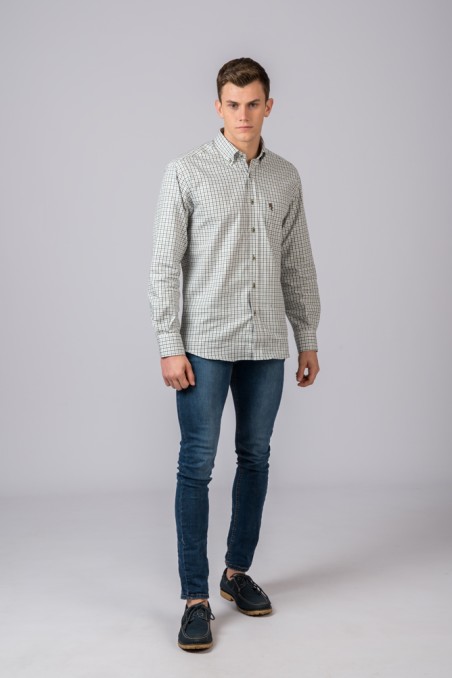 Homem com camisa xadrez e calças de ganga em fundo cinza